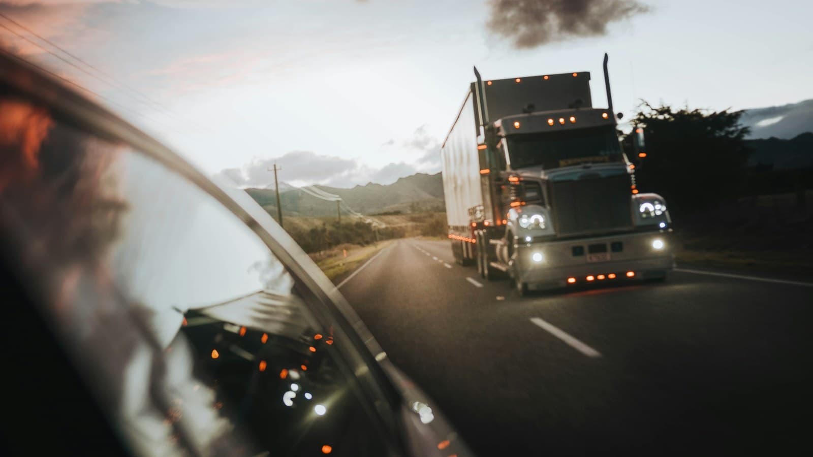 Class 8 tractor-trailer traveling an open highway at dusk